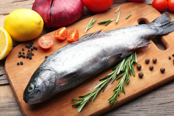 Verse rauwe vis en voedselingrediënten op tafel — Stockfoto