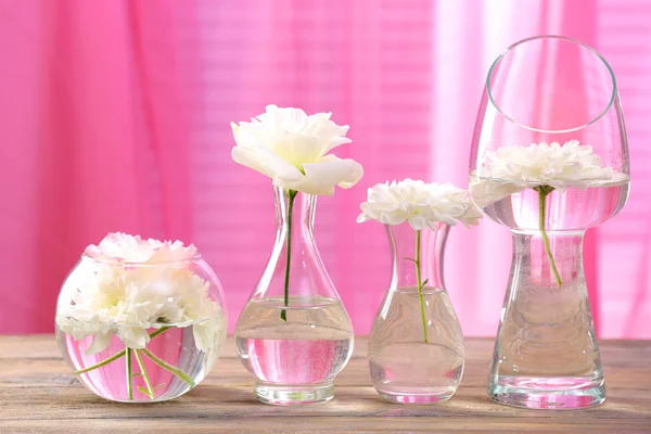 Hermosas flores en jarrones con luz de la ventana — Foto de Stock