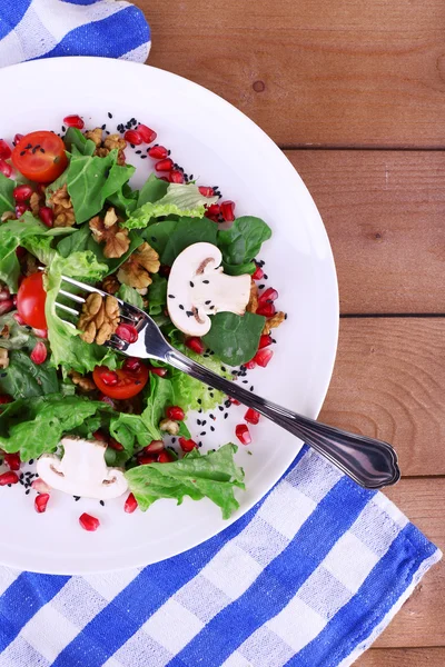 Frischer Salat mit Gemüse, Granat und Gewürzen auf dem Teller in Großaufnahme — Stockfoto