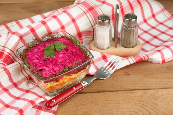 Russian herring salad in glass bowl on wooden table, on bright background — Stock Photo, Image