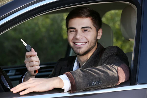 Man with car key in car — Stock Photo, Image