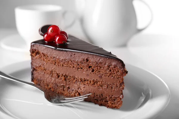 Lahodný čokoládový dort na talíři na lehkém pozadí — Stock fotografie