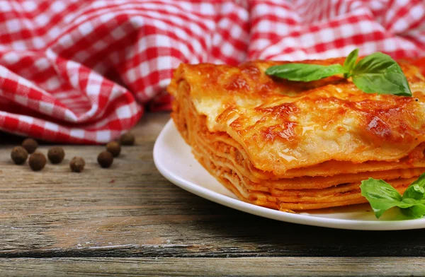 Gedeelte van smakelijke lasagne op houten tafel — Stockfoto