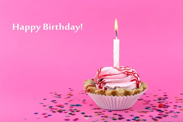 Birthday cup cake with candle and colorful stars on pink background — Stock Photo, Image