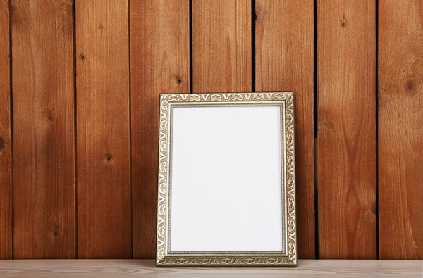 Fotoframe op houten oppervlak en een houten muur achtergrond — Stockfoto