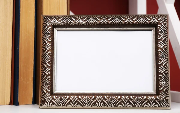 Fotoframe met boeken op plank, op een muur achtergrond kleur — Stockfoto