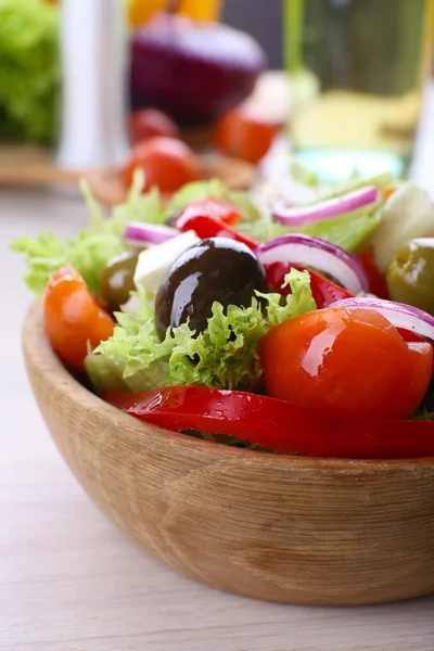 Greek salad in bow on wooden table background — Stock Photo, Image