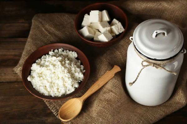 Milk can with cottage cheese on wooden background — Stock Photo, Image