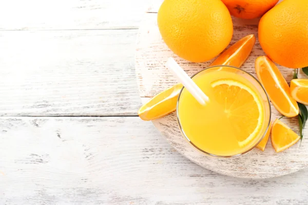 Glas Orangensaft mit Stroh und Scheiben auf Holztischhintergrund — Stockfoto