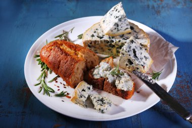 Mavi peynir dal biberiye, ekmek ve plaka ve renk ahşap masa arka plan üzerinde fındık ile