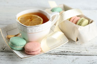 İle çay rengi ahşap arka plan üzerinde renkli macaroons