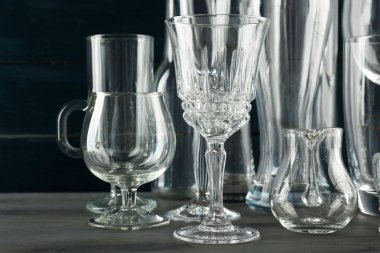 Koyu renk ahşap arka planda farklı cam eşyalar