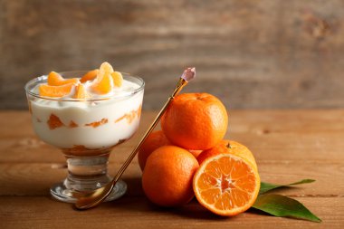 Lezzetli süt tatlı taze mandalina adet ahşap arka plan üzerinde cam kase