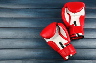 Pair of boxing gloves on color wooden background clipart