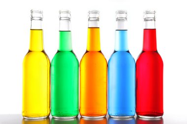 Renkli alkollü içecekler üzerinde beyaz izole cam şişelerde