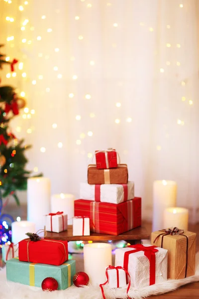 Hromadu vánoční současné krabic na kožešinové koberce na dřevěnou podlahu, na světlé pozadí — Stock fotografie