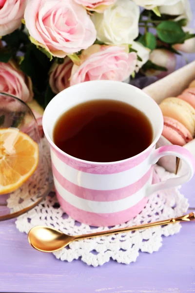 Kolorowe makaroniki filiżankę herbaty na drewniane tła — Zdjęcie stockowe