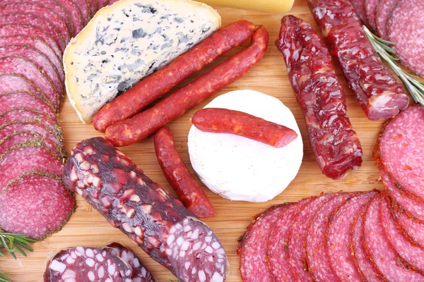 Sortiment an geräucherten Wurst und Käse auf Holz Schneidebrett Hintergrund — Stockfoto