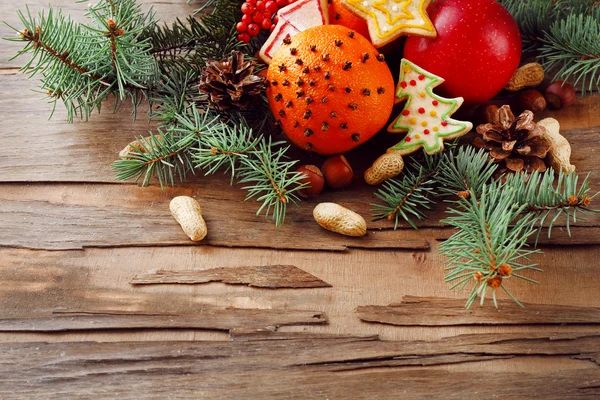 Vruchten met cookies, specerijen en takjes kerstboom op rustieke houten achtergrond — Stockfoto