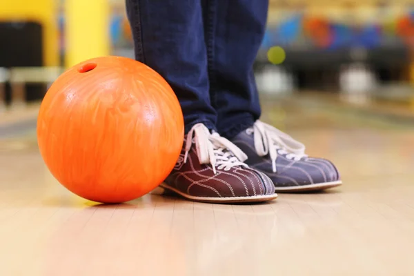 Férfi lábak és a bowling golyót sikátor háttérben — Stock Fotó