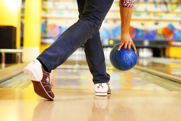 Férfi lábak és a bowling golyót sikátor háttérben — Stock Fotó