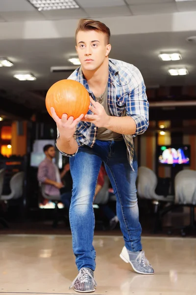 Young man playing bowling in club — Stock Photo, Image