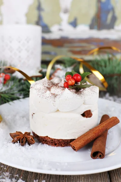 Leckerer Kuchen auf Teller mit Zimt und Sternanis auf weihnachtlichem Dekorationshintergrund — Stockfoto