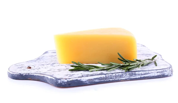 Chunk of Parmesan cheese on wooden cutting board with sprig of rosemary isolated on white — Stock Photo, Image