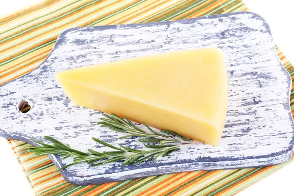 Chunk of Parmesan cheese on wooden cutting board with sprig of rosemary on napkin on white background — Stock Photo, Image