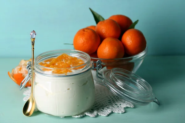 Dessert al latte saporito con pezzi di mandarino fresco in vaso di vetro, su sfondo di legno a colori — Foto Stock