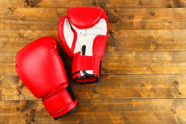 Par de luvas de boxe em pranchas de madeira fundo — Fotografia de Stock