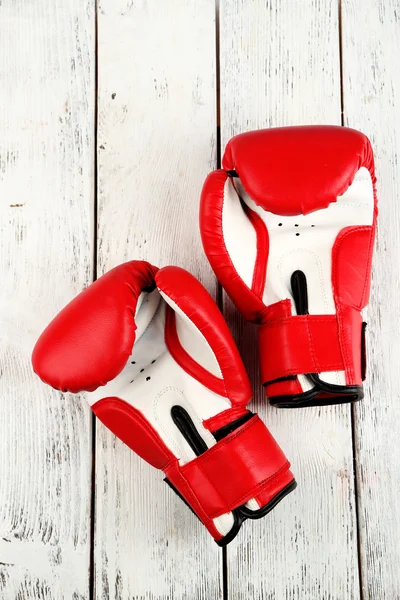 Paire de gants de boxe sur fond en bois couleur — Photo