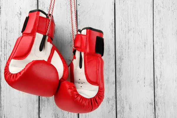 Par de luvas de boxe na cor de fundo de madeira — Fotografia de Stock