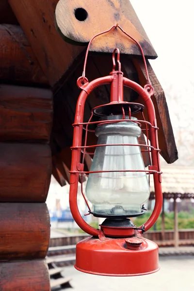 Kerosene lamp hanging on wooden house, outdoors — Stock Photo, Image