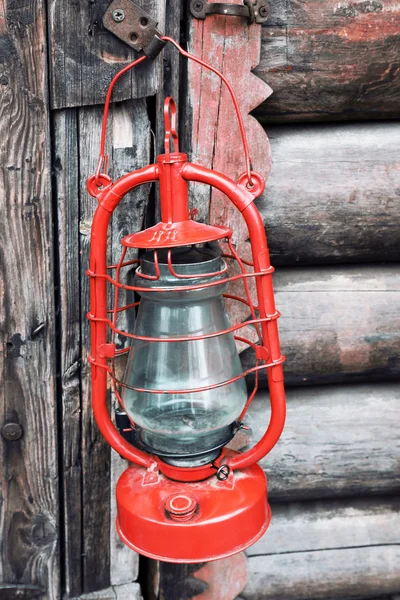 Kerosene lamp on wooden door background — Stock Photo, Image