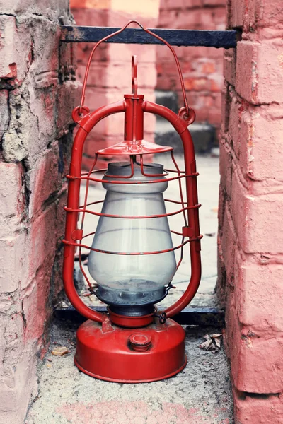 Керосиновая лампа на разрушенном фоне кирпичной стены — стоковое фото