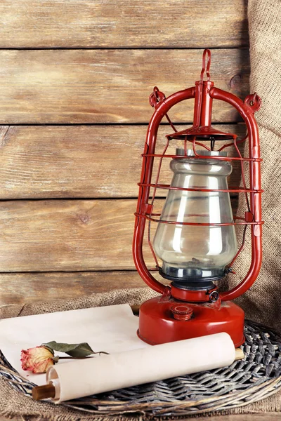 Керосиновая лампа с сушеной розой и буквой на плетеном коврике и деревянных досках фона — стоковое фото