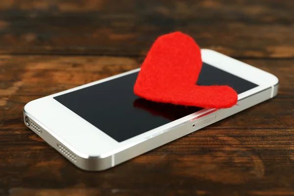 Kırmızı kalp ile akıllı cep telefonu — Stok fotoğraf