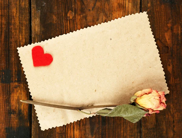 Χαρτί με μικρή καρδιά και αποξηραμένα τριαντάφυλλο — Φωτογραφία Αρχείου