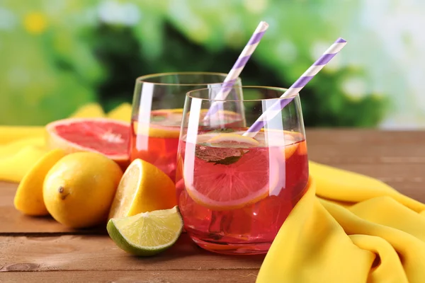 Roze limonade in glazen op tafel op natuurlijke achtergrond — Stockfoto