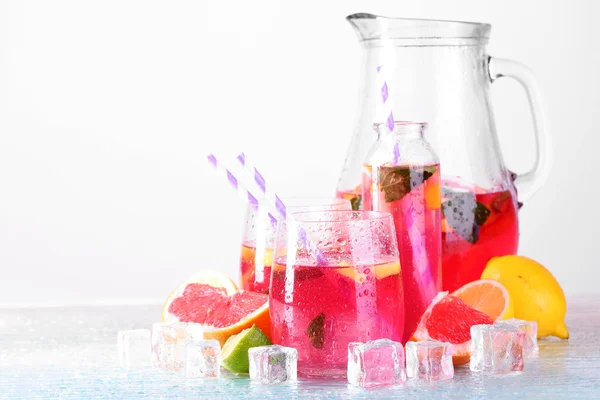 Růžové limonády ve skle a džbán na světlé pozadí — Stock fotografie