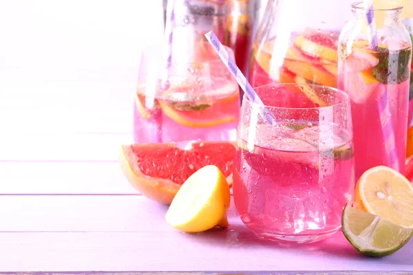 Rosa Limonade in Gläsern und Krug auf dem Tisch in Großaufnahme — Stockfoto