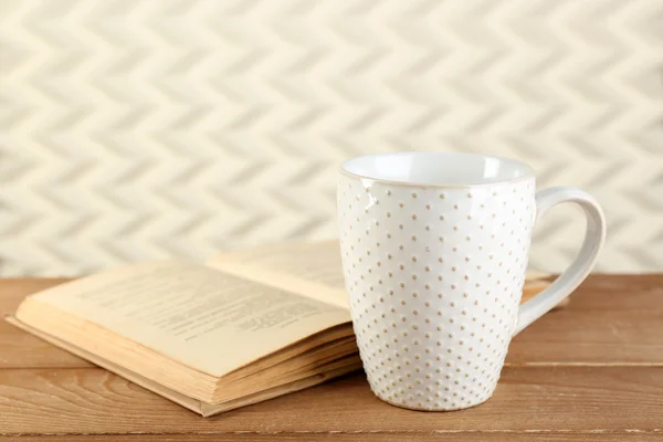 Taza de té y libro sobre la mesa, sobre fondo claro — Foto de Stock