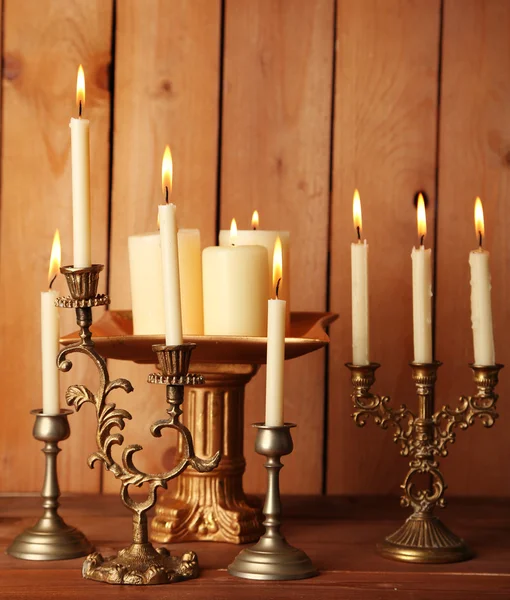 Candelabros retro con velas sobre fondo de madera — Foto de Stock