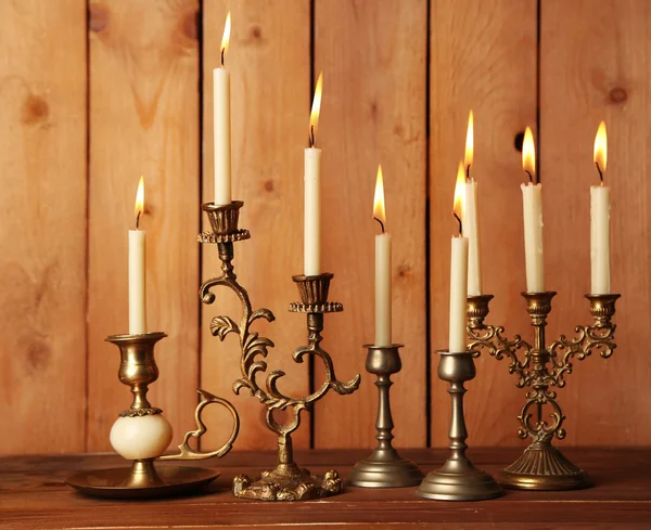 Ρετρό κηροπήγια με κεριά σε ξύλινα φόντο — Φωτογραφία Αρχείου
