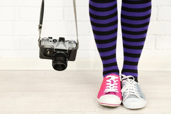 Chica en zapatillas con cámara de fotos retro en la habitación — Foto de Stock