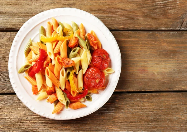 Pastasallad med paprika, morot och tomat på träbord bakgrund — Stockfoto
