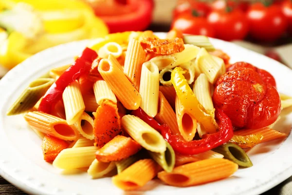 Pastasalade met peper, wortel en tomaten op houten tafel achtergrond — Stockfoto