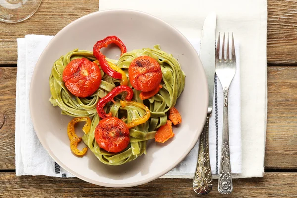 Leckere Pasta mit Paprika, Karotten und Tomaten auf Holztischhintergrund — Stockfoto