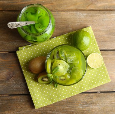 Ahşap arka plan üzerinde cam kase lezzetli kivi reçeli